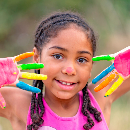 Portrait of a cute cheerful girl with painted hands, happiness of creation concept